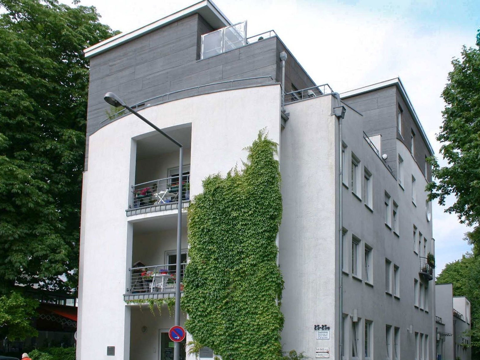 Aussenansicht: modernes funktionales Gebäude an dem Efeu an einer Seite nach oben rankt